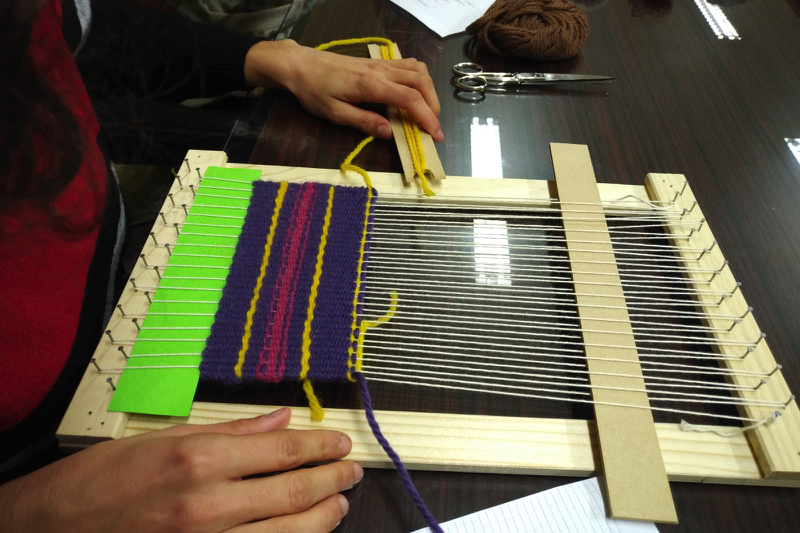 Fili, telai, gomitoli e colori si mescolano e compongono nelle foto del laboratorio di tessitura di Valeria Belli.