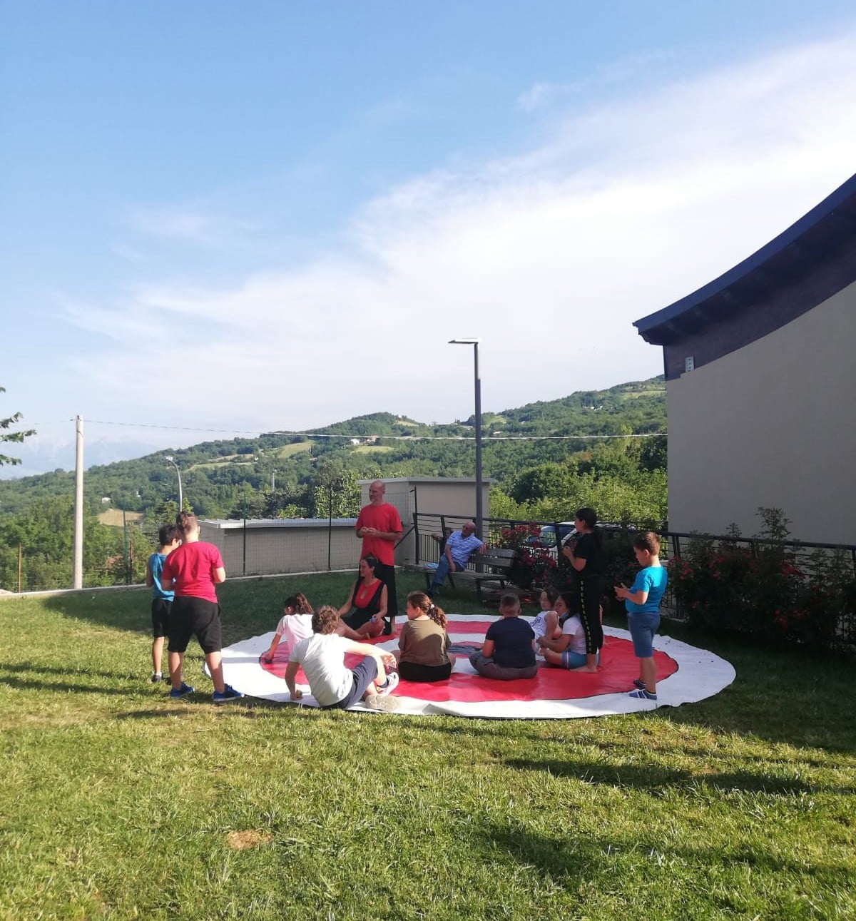 Tutti in cerchio sul grande tappeto bianco e rosso per partecipare al Circo Sociale: condividere e imparare non è mai stato così divertente come con Valentina Floro e Cristiano Coia del Circo TiC - La Tenda in Circolo!